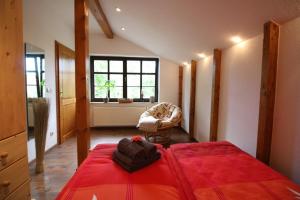 a bedroom with a red bed and a chair at Ferienwohnung an der südlichen Boddenküste in Bartelshagen