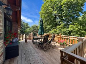 a wooden deck with a table and an umbrella at Ferienwohnung an der südlichen Boddenküste in Bartelshagen