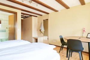 a bedroom with a bed and a table and chairs at La Collina Coliving and Coworking in Grächen