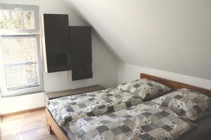 una camera da letto con un letto con un piumone e una finestra di Waldidyll Brunni a Marlow