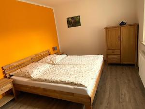 a bedroom with a bed and a wooden cabinet at Ferienhaus VogelMeer in Marlow
