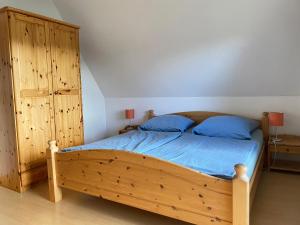 a bedroom with a wooden bed and a wooden cabinet at Finnhaus Lisa in Marlow
