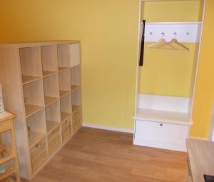 a room with a closet with yellow walls and wooden floors at FeWo Schwalbennest in Marlow