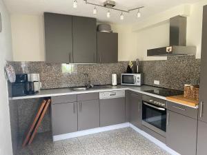 a kitchen with gray cabinets and a sink at Ferienhaus "Am Wald" in Behrenwalde