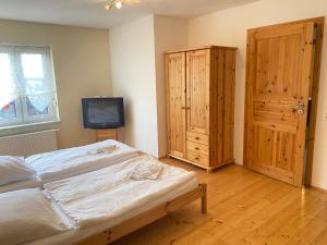 a bedroom with a bed and a tv in it at Ferienhaus "Am Wald" in Behrenwalde