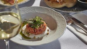 a plate of food on a table with a glass of wine at Carmella Spa & Boutique Hotel in Haifa