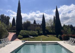 a swimming pool in front of a house with trees at Podere Fignano, holiday home - apartments renovated 2024 - new swimming pool in Montaione +68 photos