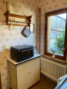 a microwave sitting on top of a cabinet next to a window at Ferienwohnung Graureiher in Marlow