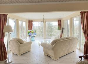 a living room with two chairs and a tv at Ferienvilla Recknitztal in Marlow