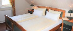 a bedroom with a bed with white sheets and pillows at Ferienvilla Recknitztal in Marlow