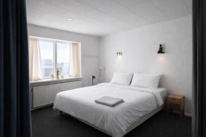a bedroom with a white bed and a window at PAK Central apartment Odense C in Odense