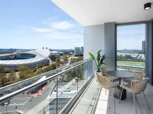 a balcony with a table and chairs and a view of a stadium at Olympic Optimum Accor in Sydney