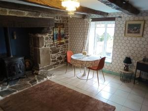 a dining room with a table and a fireplace at The Old Cider Press in Carnoët