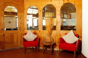 a room with two red chairs and a vase on a table at La Collina Coliving and Coworking in Grächen