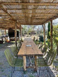 a wooden table and chairs under a wooden pergola at AgriGlamping La Diaccia in Serravalle Pistoiese