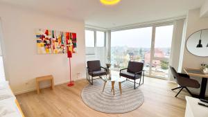 a living room with chairs and a table in a room at Stadtloft Penthouse "Eversten" Neubau Business Apartments für Projekt- und Firmenaufenthalte in Oldenburg