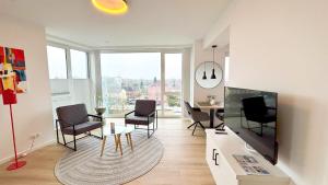 a living room with chairs and a table and a dining room at Stadtloft Penthouse "Eversten" Neubau Business Apartments für Projekt- und Firmenaufenthalte in Oldenburg