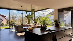 a kitchen and living room with a lot of windows at Modern Luxury Apartment in Karsau