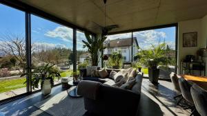 a living room with a couch and a large window at Modern Luxury Apartment in Karsau