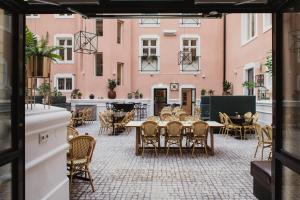 a patio with tables and chairs in front of pink buildings at Home Hotel Victoria in Jönköping