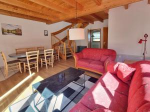 a living room with a red couch and a table at Haus 2 Naturerlebnisse und Erholung im Natur Ferienpark in Nieheim