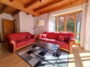 a living room with a red couch and a table at Haus 2 Naturerlebnisse und Erholung im Natur Ferienpark in Nieheim