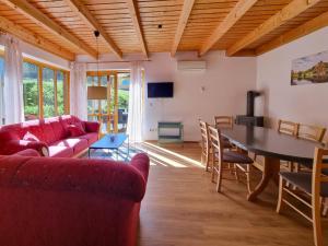 a living room with a red couch and a table at Haus 2 Naturerlebnisse und Erholung im Natur Ferienpark in Nieheim
