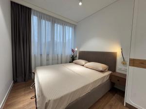 a bedroom with a bed and a large window at Modern apartment in Yerevan