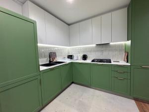 a green and white kitchen with green cabinets at Modern apartment in Yerevan