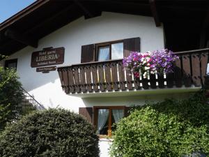 a building with a balcony with flowers on it at Hotel Liberia in Oberstdorf