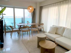 a living room with a couch and a table and chairs at O2 capsule house OTARU in Otaru