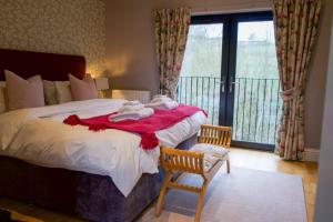a bedroom with a bed with towels on a red blanket at Snowdrop Lodge in Errol