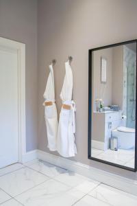 a mirror in a bathroom with white towels and a sink at Snowdrop Lodge in Errol