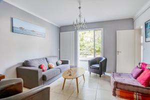 a living room with a couch and a table at Villa Le Deck - Grande maison familliale proche plage in Arcachon