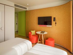 a bedroom with a bed and a table and a tv at MU Hotel in Ipoh +57 photos