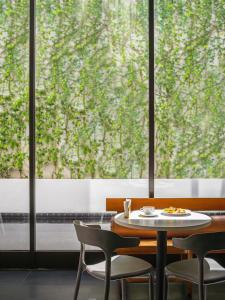 a table and chairs in front of a large window at MU Hotel in Ipoh