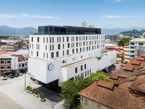 a white building with a clock on it in a city at MU Hotel in Ipoh