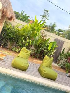 two lime green inflatable pillows next to a swimming pool at Villa Saraswati I in Uluwatu