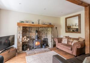 a living room with a stone fireplace and a couch at Swale View in Feetham