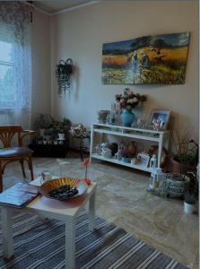 a living room with a table and a painting on the wall at VIAMILANO25 in Mirandola