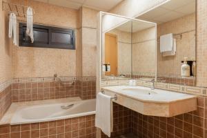 a bathroom with a tub and a sink and a mirror at Hotel SB Express Tarragona in Tarragona +22 photos