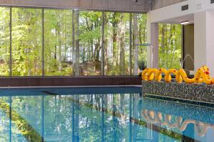 a swimming pool with a view of the trees at Aquamarina Międzyzdroje Marina Invest in Międzyzdroje