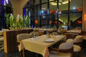 a restaurant with tables and chairs and a large window at Gelevera Park - Otel Spa Restaurant in Espiye
