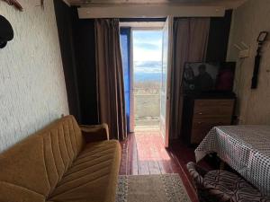 a bedroom with a couch and a window with a view at Enjoy Georgian Regions in Tʼetʼri Tsqaro