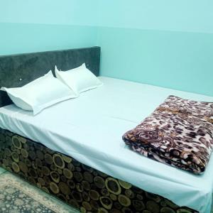 a bed with white sheets and a blanket on it at Hotel THAR in Bikaner
