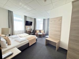 a hotel room with a large bed and a desk at Hotel Hohenstaufen in Koblenz +58 photos