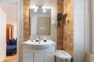 a bathroom with a white sink and a mirror at Aila Stay in Corfu