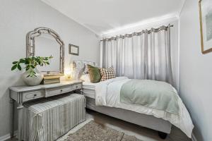 a bedroom with a bed with a mirror and a table at The Willow Cottage in Oakdale