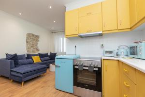 a kitchen with yellow cabinets and a blue appliance at Aila Stay in Corfu +19 photos