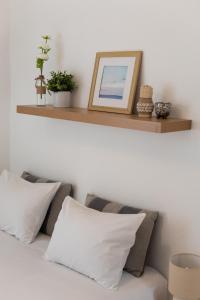 a shelf above a bed with pillows and a picture at Sesimbra Cozy House BBQ & Terrace - MADA HOUSE's in Sesimbra